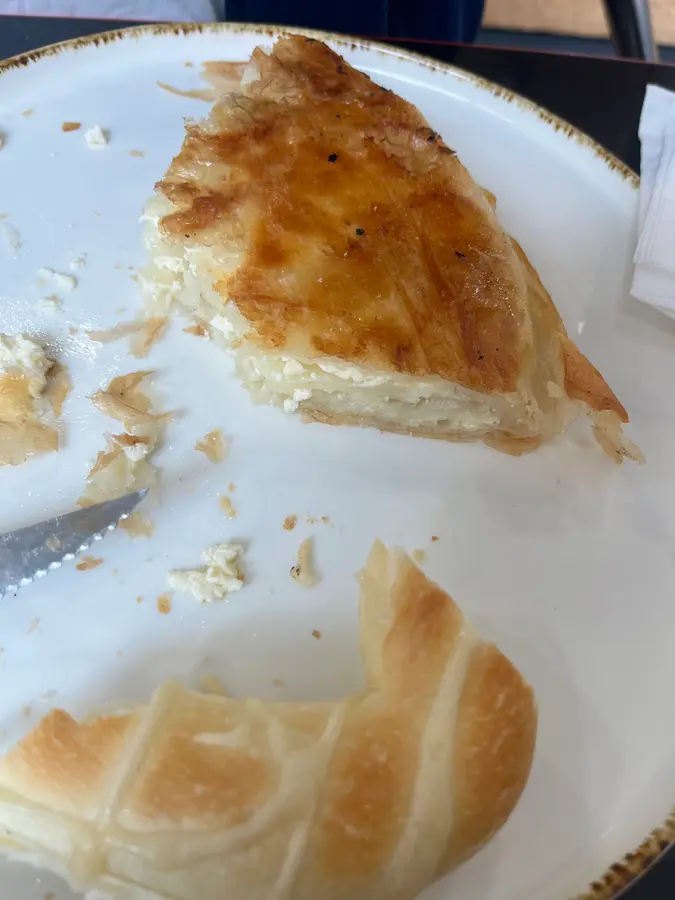 Ein angeschnittener Burek mit Käse auf einem Teller